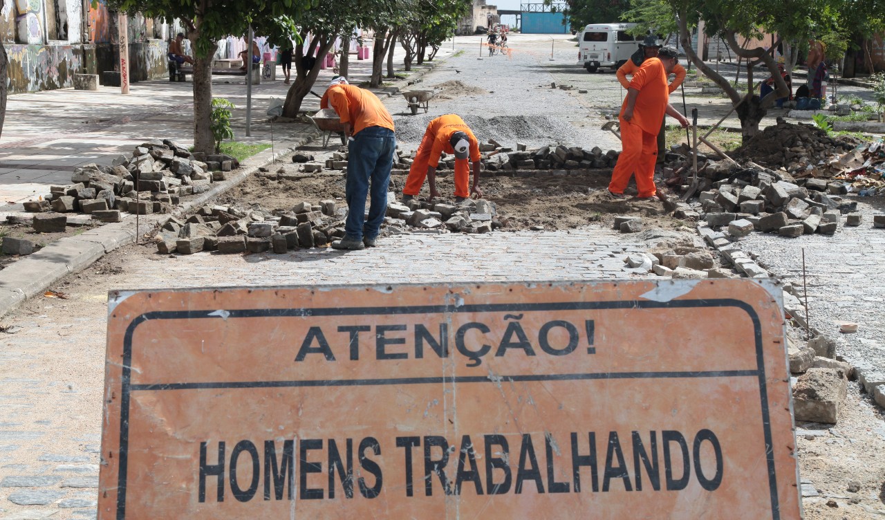 homens trocando a pavimentação de uma rua